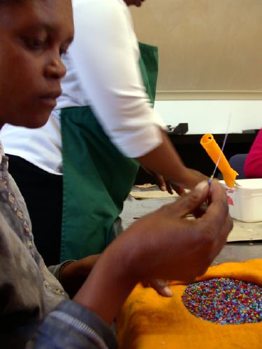 Die klitzekleinen Perlen werden auf einen dnnen Draht gespiet und spter auf den Deckel von Notizbchern geklebt 