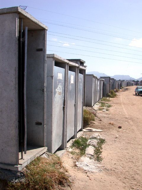 Toiletten wurden direkt an den Rand eines Flutungskanals gebaut. Das Camp ist wild entstanden, wird aber geduldet und hat zumindest eine rudimentaere Infrastruktur