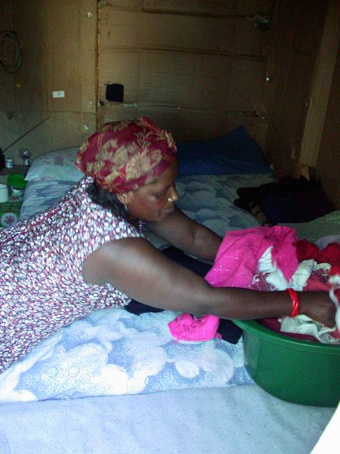  Revina Gwavi arbeitet mit mir im Museum. Sie stickt die mit Filzstift geschriebenen Gedanken der Ex-District-Sixer auf ein langs Tuch. Im Township Langa wohnt sie seit 1997. Bleiben moechte sie nicht. Doch in ihrer Heimat am Ostkap haette sie noch weniger.