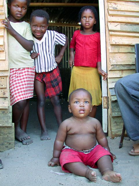 Stolz praesentiert der Nachbar seinen juengsten Spross. Doch dem ist der weisse Mann mit der Kamera nur suspekt.