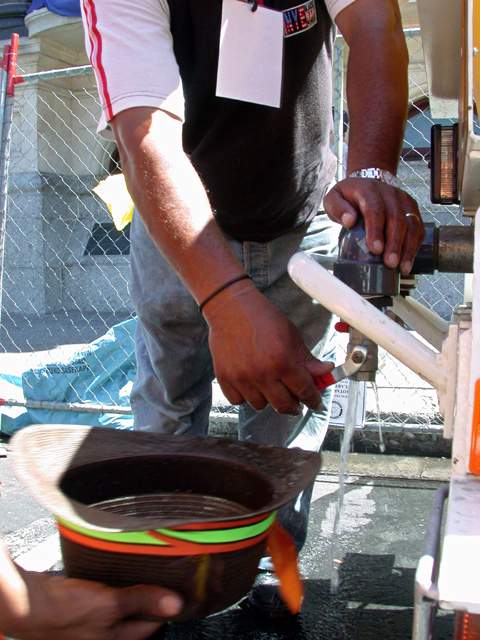 Ein Hut voll Wasser kann fuer einen kuehlen Kopf sorgen, wenn die Sonne brennt.